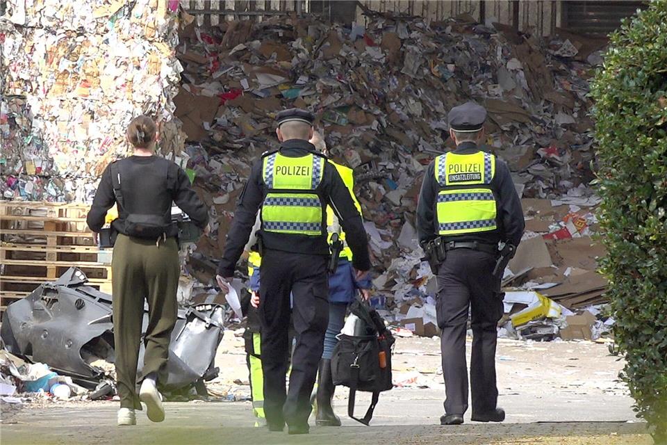 Einsatzkräfte der Polizei ermitteln auf dem Gelände einer Recyclingfirma, wo ein toter Mann gefunden wurde. Bodo Marks/dpa