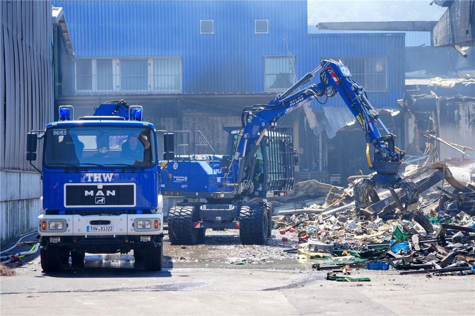 Einsatzkräfte des Technischen Hilfswerks (THW) beseitigen mit einem Bagger Schutt nach dem Feuer in einem Gewerbegebiet in Stuttgart.Enrique Kaczor/dpa