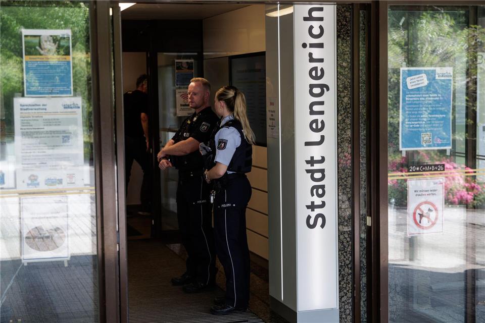 Einsatzkräfte stehen am Eingang des Rathauses.David Ebener/dpa