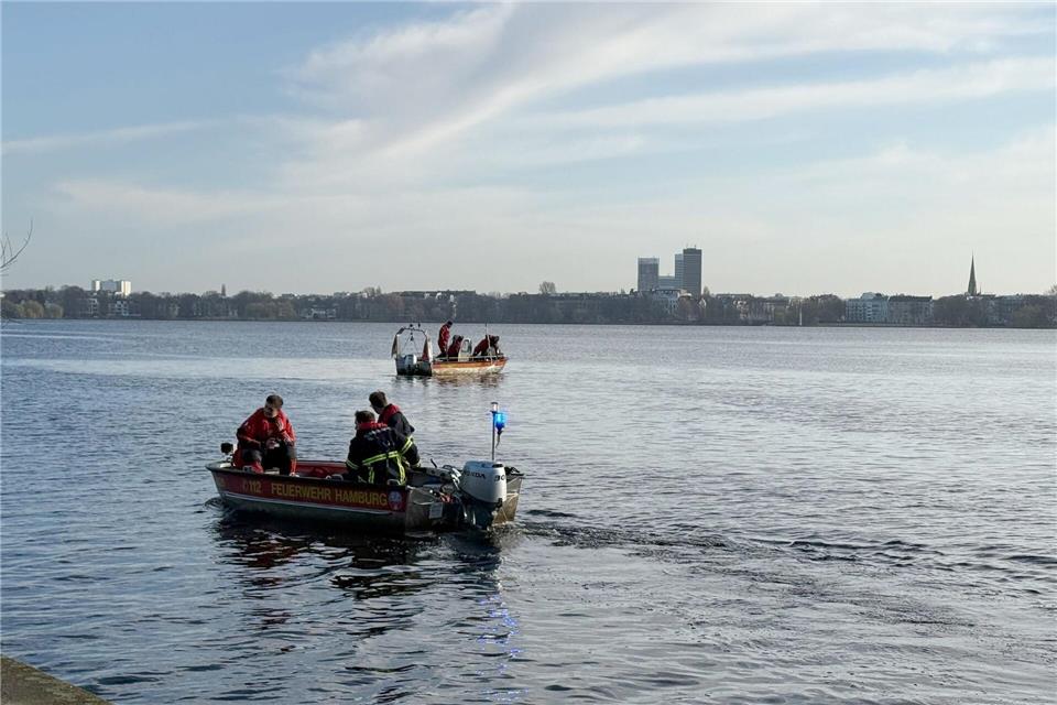 Einsatzkräfte von Feuerwehr, DLRG und Polizei suchen auf der Außenalster nach einer möglicherweise vermissten Person.Katrin Luxenburger/dpa