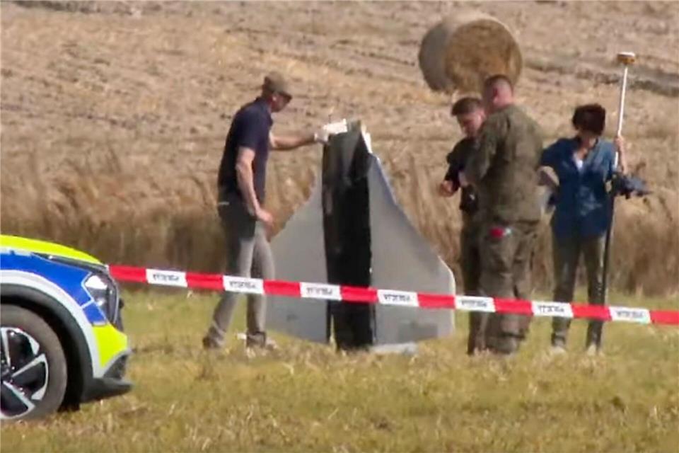 Drohnen über Polen – Pistorius: „Gezielte Kursführung“ Einsatzkräfte von Polizei und Militärpolizei sichern Teile einer beschädigten Drohne.Rafal Niedzielski/AP/dpa