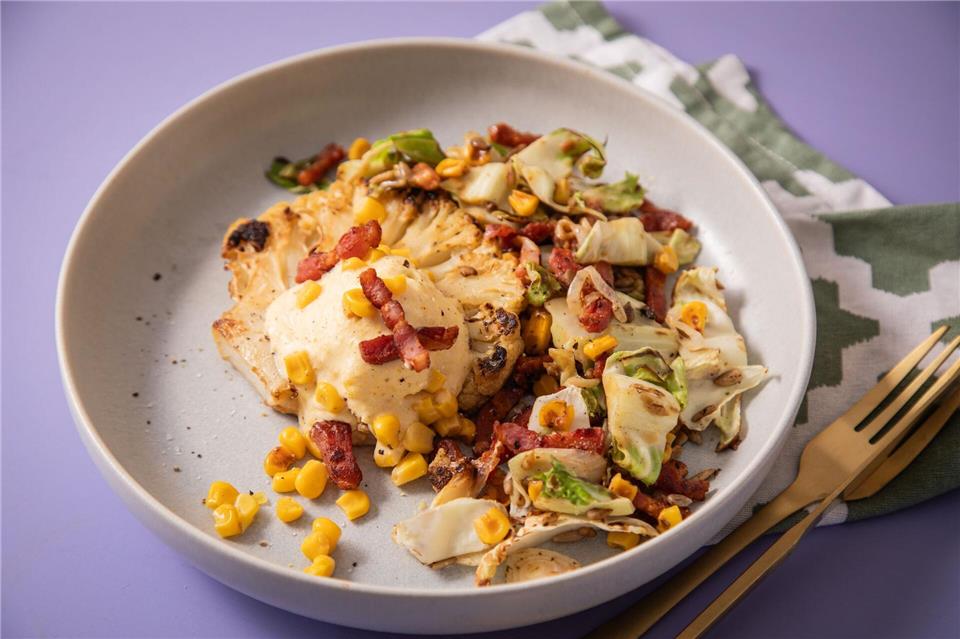 Eis und Blumenkohl? Na, klar: Das Blumenkohl-Schnitzel wird mit Maiseis, Bacon, gebratenen Blumenkohl-Blättern, Mais und Sonnenblumenkernen getoppt. Christin Klose/dpa-tmn