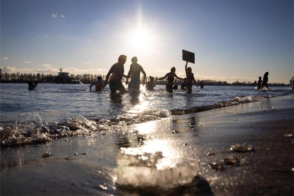 Lockdown-Trend Eisbaden: Heilsversprechen oder Risiko? Eisbaderinnen und Eisbader baden für einen guten Zweck in der eisigen Elbe bei Övelgönne. Foto: Christian Charisius/dpa