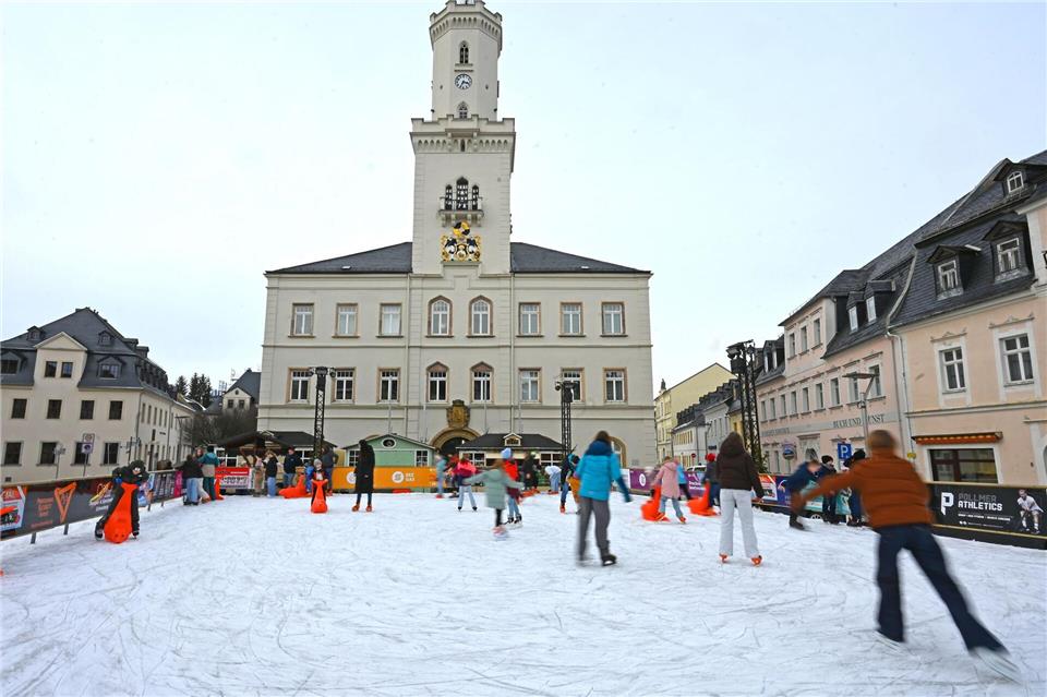 Eislaufen vor historischer Kulisse: Auf dem Markt in Schneeberg tummeln sich zahlreiche Schlittschuhläufer.David Hammersen/dpa
