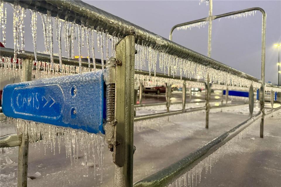 Eiszapfen hängen an einem Geländer während eines Wintersturms auf einem Parkplatz.John Raby/AP/dpa