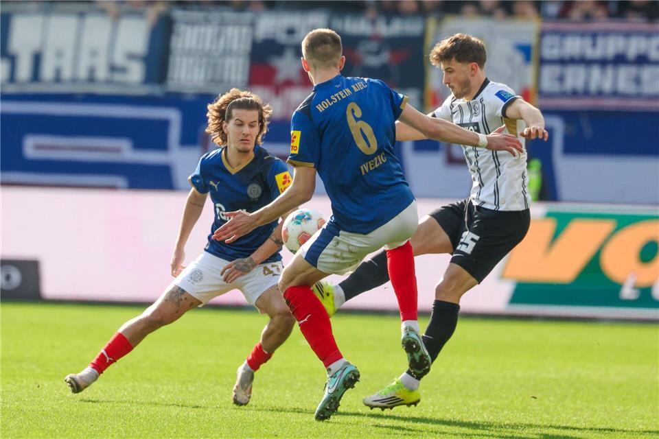 Elversbergs Lukas Petkov (r) im Duell mit den Kielern John Tolkin (l) und Marko Ivezic.Frank Molter/dpa