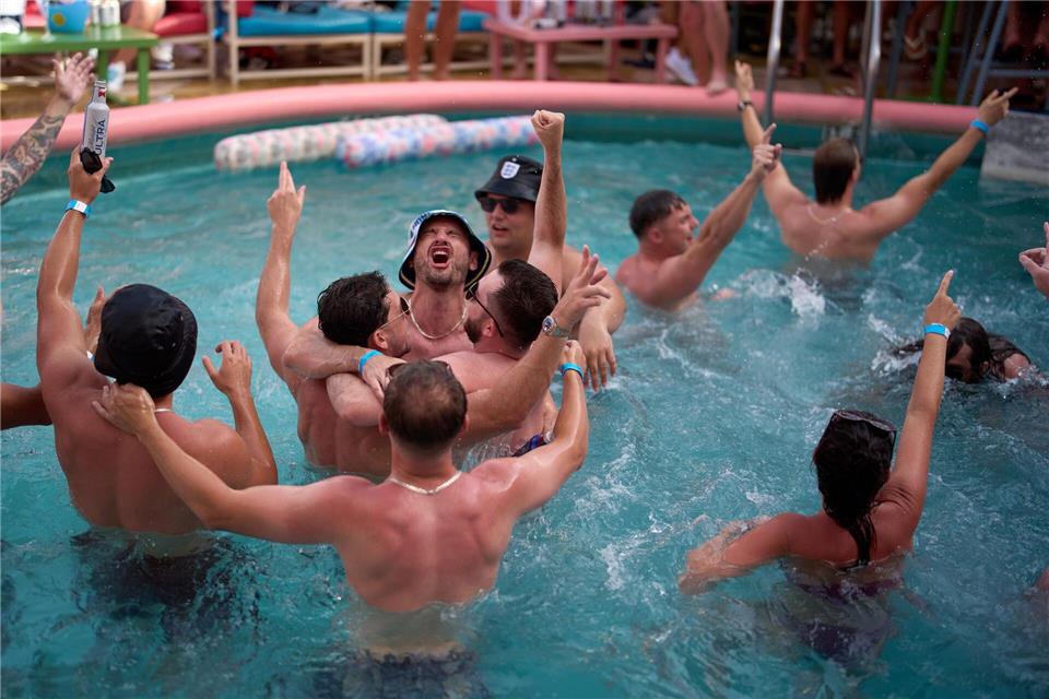 Englische Fußballfans singen zur Musik mit, während sie am Vorabend ihres Viertelfinalspiels im „The Clevelander“ am Ocean Drive in Miami baden.Rebecca Blackwell/AP/dpa