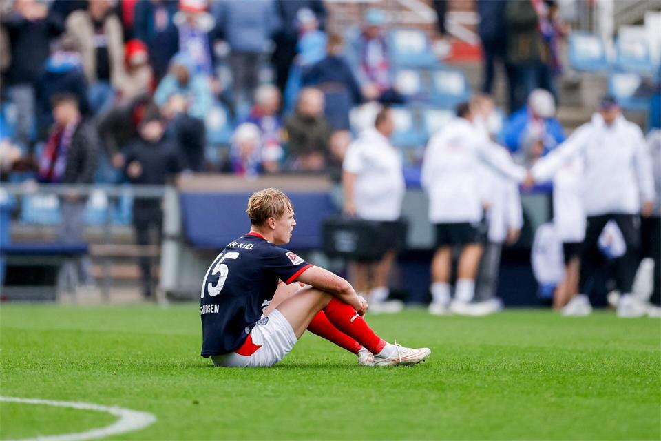 Entäuscht sitzt der Kieler Kasper Davidsen nach dem Abpfiff auf dem Rasen.Philipp Szyza/dpa
