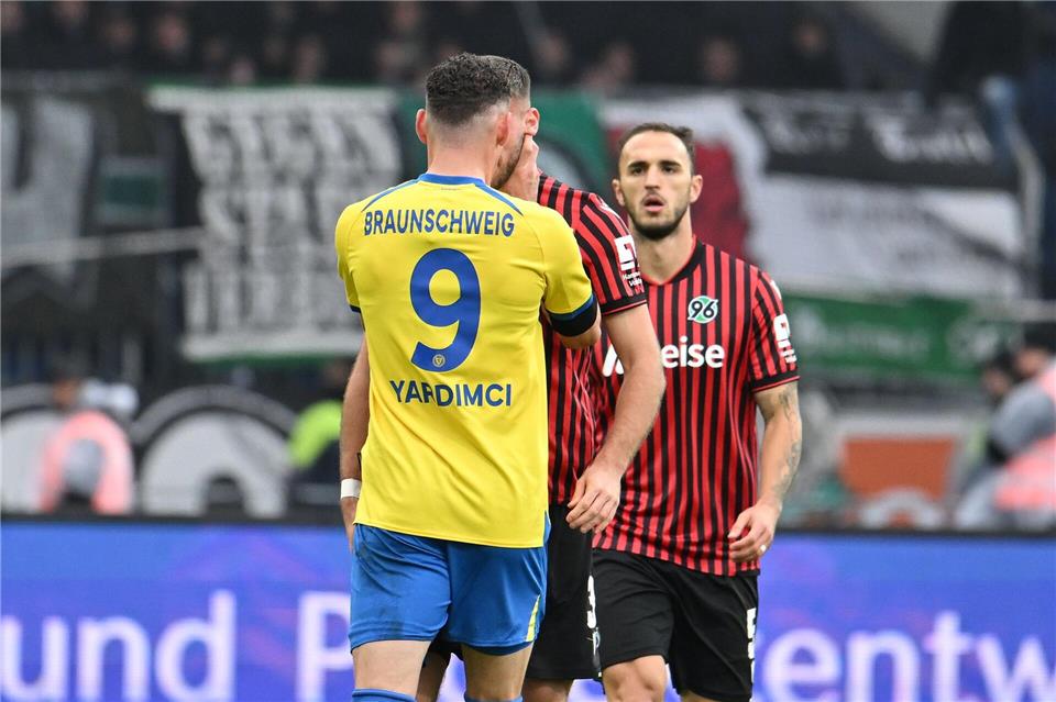 Erencan Yardimci von Eintracht Braunschweig fasst seinem Gegenspieler Boris Tomiak beim Derby gegen Hannover 96 mit beiden Händen an den Hals.Swen Pförtner/dpa