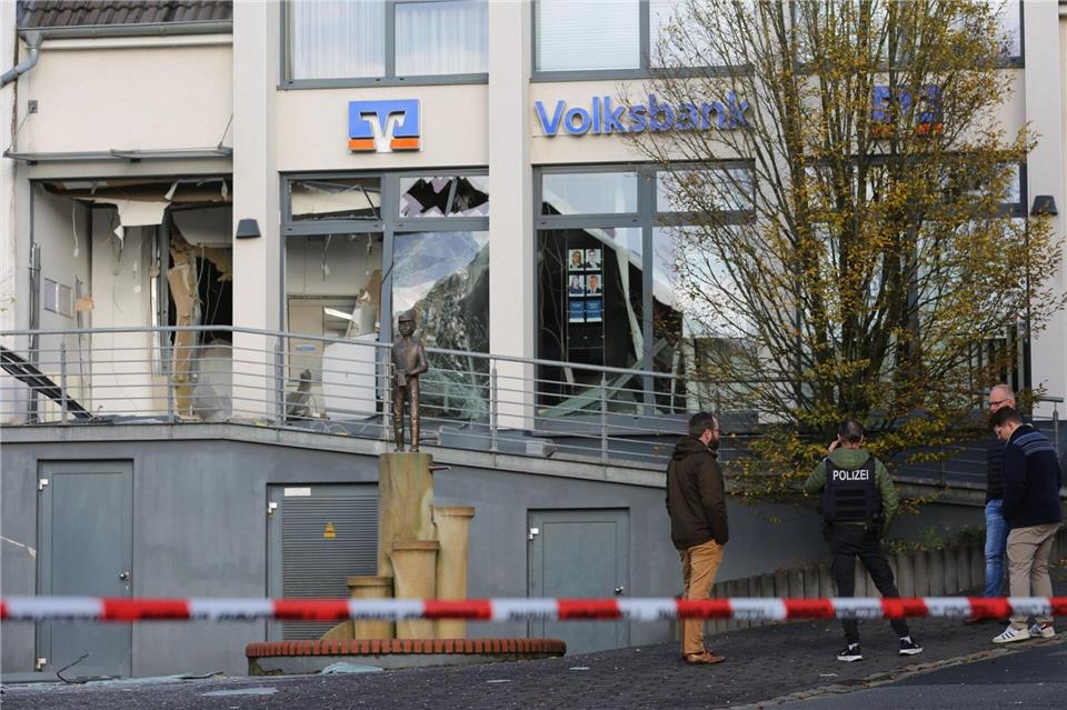 Ermittler der Polizei stehen in Paderborn vor einer beschädigten Bankfiliale. Christian Müller/dpa