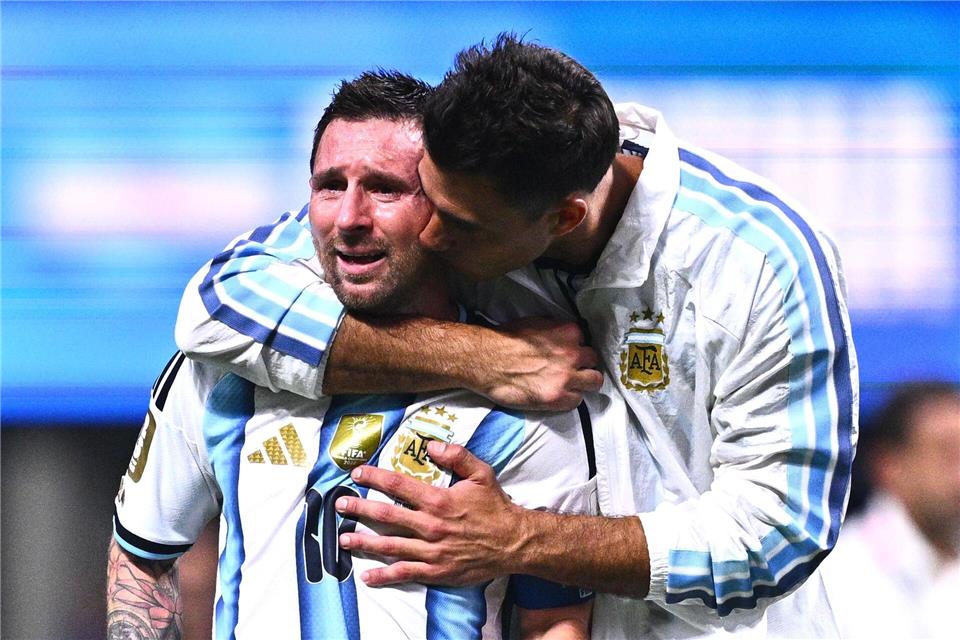 Ersatztorhüter Juan Musso (r) nimmt den weinenden Messi in den Arm.Tom Weller/dpa