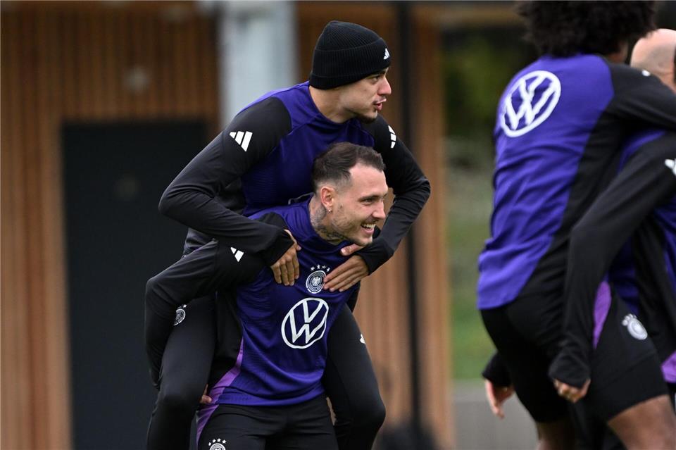 Erst Huckepack dann Doppelpack? Beim Training der Fußball-Nationalmannschaft vor dem WM-Quali-Spiel gegen Luxemburg trägt David Raum Aleksandar Pavlovic auf den Schultern.Federico Gambarini/dpa