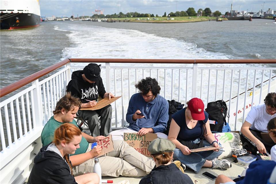 Erste Klimaaktivisten reisen mit der Fähre nach Borkum, um dort bei einem Protestcamp gegen die Erdgasbohrungen vor der Insel zu demonstrieren. Lars Penning/dpa