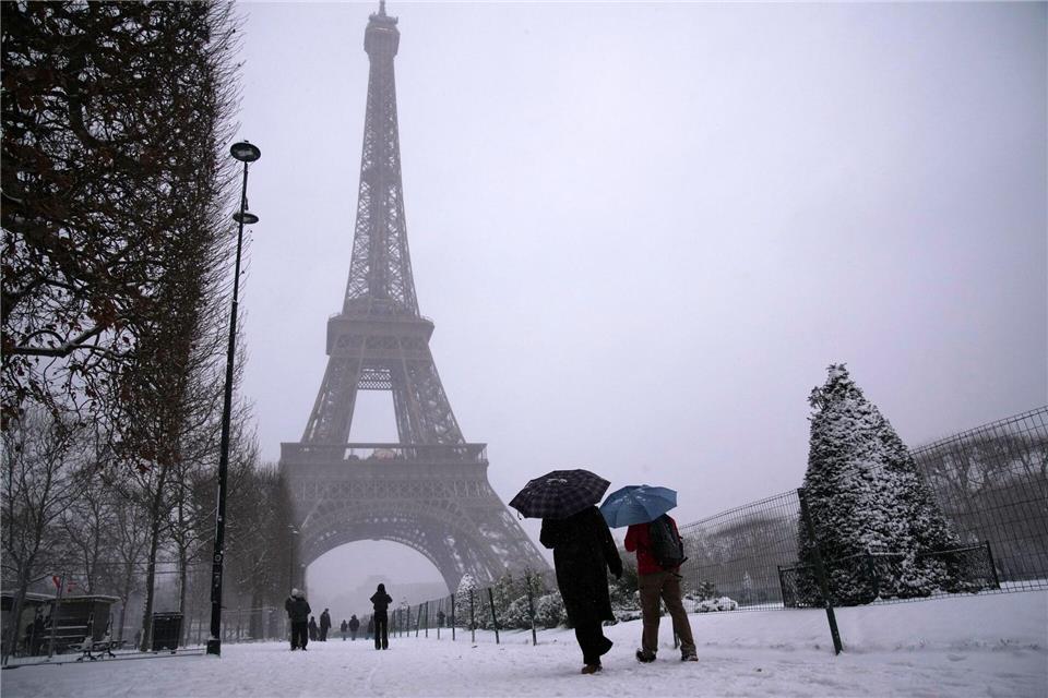 Es schneit unter dem Eiffelturm.Christophe Ena/AP/dpa