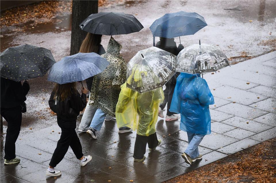 Bilder des Tages Es wird Regen geben! Jugendliche halten Schirme bei Regenwetter in Dresden.Robert Michael/dpa