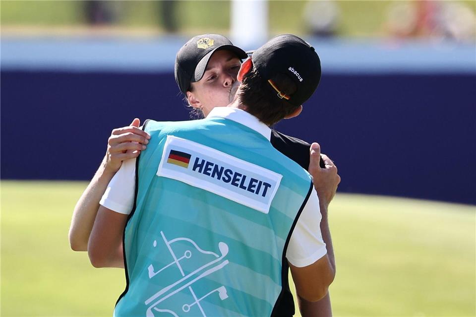 Esther Henseleit (l) küsst ihren Freund und Caddie Reece Phillips.Jan Woitas/dpa