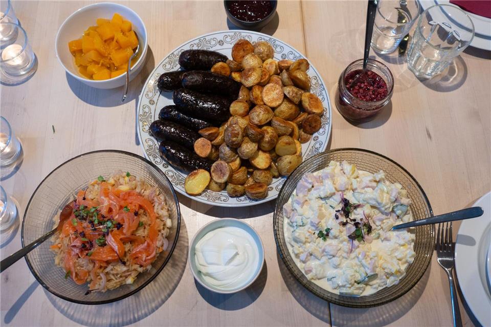 Estnische Wintergerichte: Blutwurst aus dem Ofen (M), dazu Sauerkrautsalat mit Lachs (l. u.) und Kartoffelsalat mit Sour Cream (r. u.).Andreas Drouve/dpa-tmn