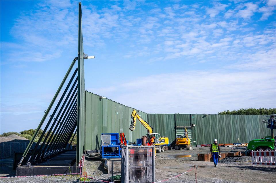 Windstrom durchs Watt leiten: Wie wird Norderney unterbohrt?  Etwa zehn Meter hohe Lärmschutzwände schirmen die Baustelle ab. Sina Schuldt/dpa