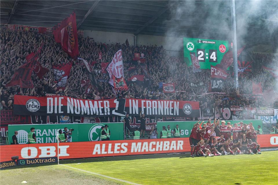 Euphorisch posieren die Spieler des 1. FC Nürnberg nach dem Derbyerfolg in Fürth vor den Fans.Daniel Löb/dpa