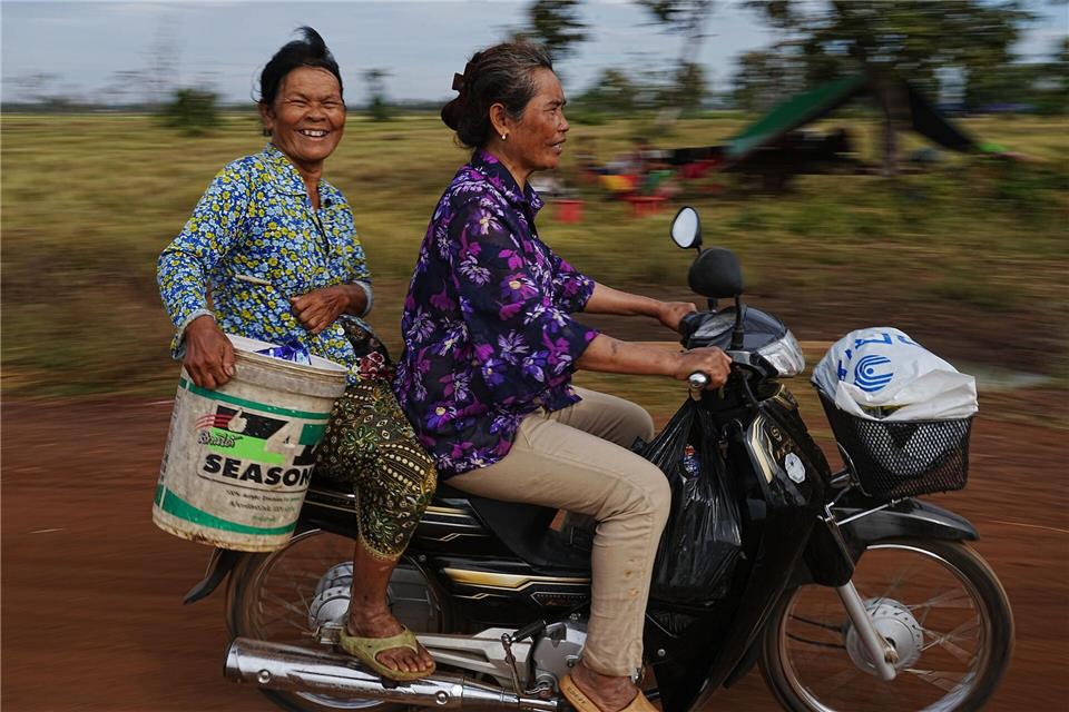Evakuierte tragen Wasser, als sie auf dem Reisfeld von Chonkal in der Provinz Oddar Meanchey in Kambodscha Zuflucht suchen, nachdem sie nach erneuten Kämpfen zwischen Thailand und Kambodscha aus ihrer Heimat geflohen sind.Heng Sinith/AP/dpa