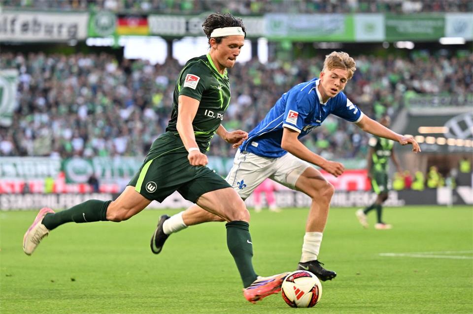 Fabian Reese vom VfL Wolfsburg (l) wird vom Darmstädter Nicolas Verkooijen verfolgt.Swen Pförtner/dpa