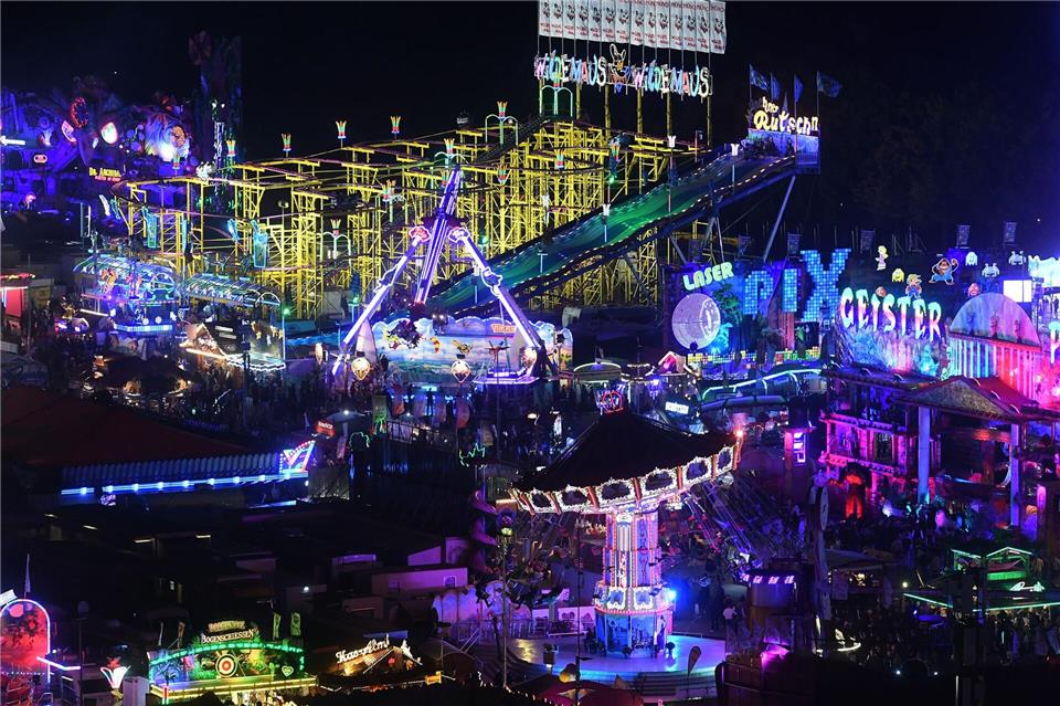 Fahrgeschäfte leuchten auf dem Oktoberfest.Felix Hörhager/dpa