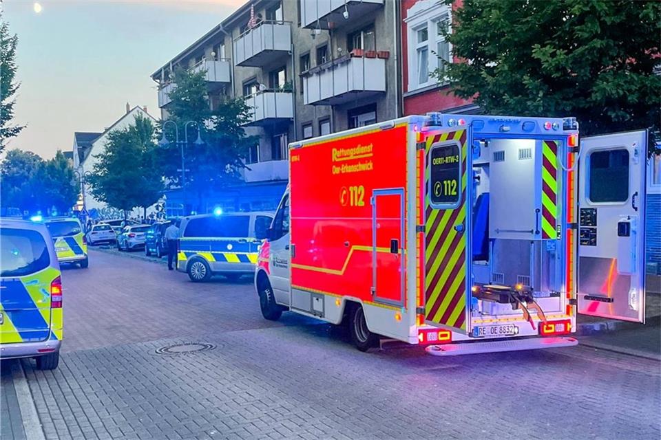 Fahrzeuge von Polizei und Rettungsdienst stehen an einer Straße.