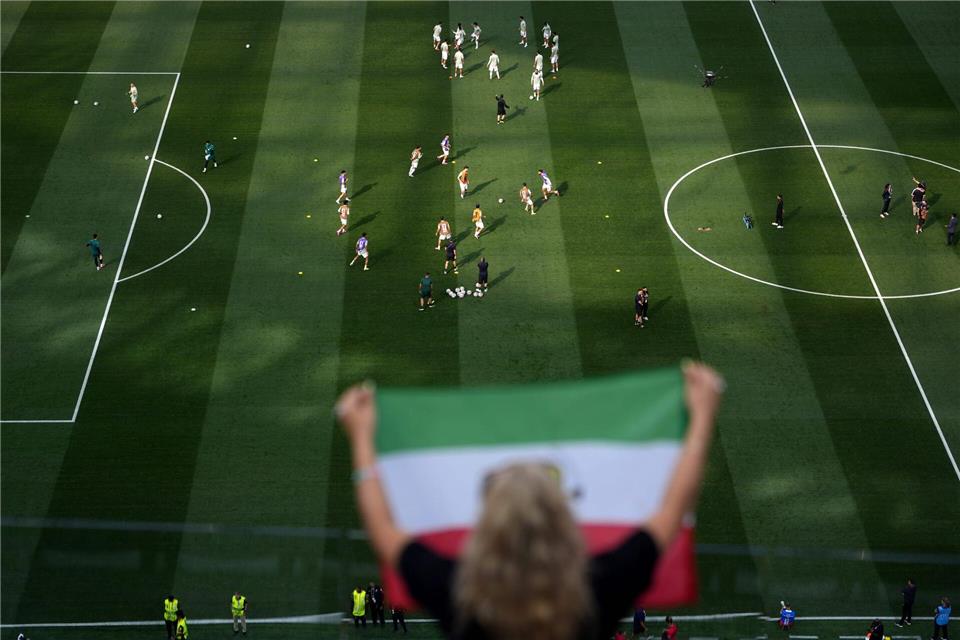 Fans jubeln, während sich die iranischen Spieler vor dem WM-Spiel gegen Neuseeland aufwärmen.Jae C. Hong/AP/dpa