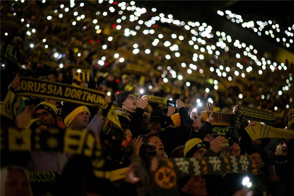 Fans stehen beim traditionellen Weihnachtssingen auf der Süd-Tribüne im BVB-Stadion.Fabian Strauch/dpa