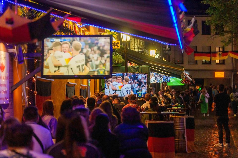 Fans verfolgen vor einer Gaststätte ein Fußballspiel. (Illustration)Andreas Arnold/dpa