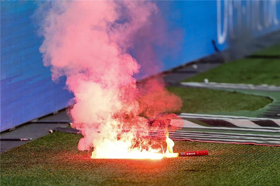 Fans von Wolfsburg werfen Leuchtfackeln auf den Platz.Andreas Gora/dpa