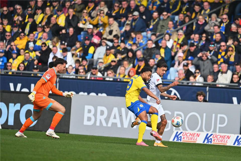 Fast das 1:0 für Münster: Oliver Batista-Meier (r) nutzt einen Fehler der beiden Braunschweiger Elhan Kastrati (l) und Leon Bell Bell, spielt den Ball dabei aber mit dem Arm.Swen Pförtner/dpa