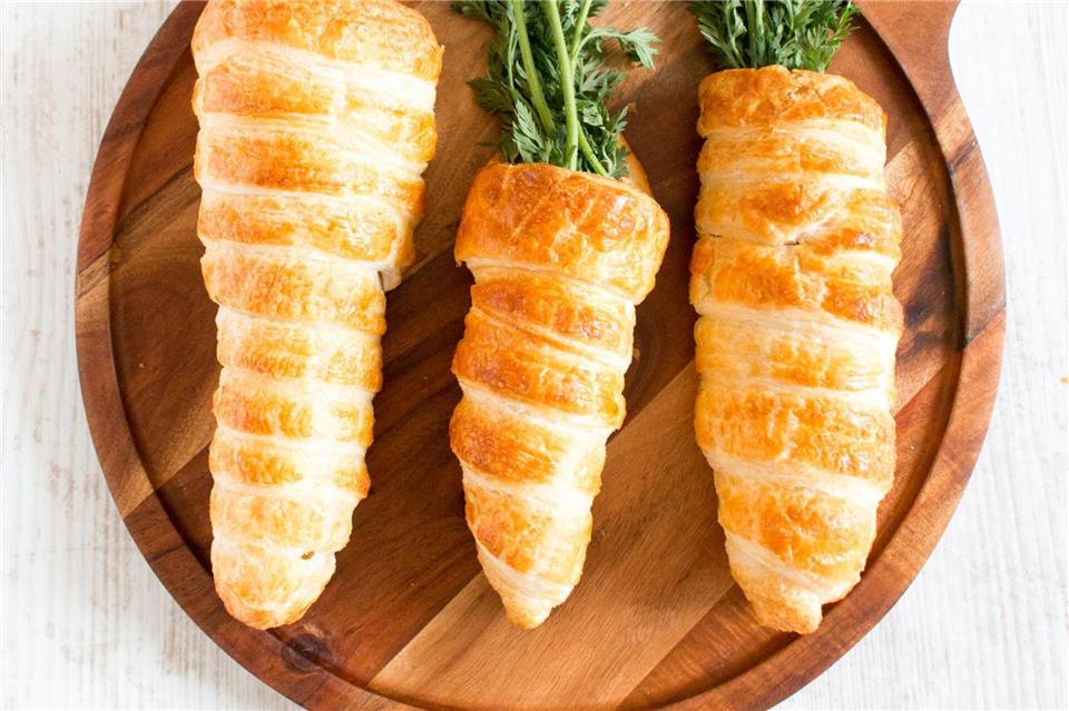 Fast zu schade zum Essen: Aus Blätterteig geformte Hörnchen werden mit einer Paste aus Hummus, Linsen, Möhren und Walnüsse gefüllt. Glatte Petersilie wird zum Karottengrün. gernekochen.de/dpa-tmn