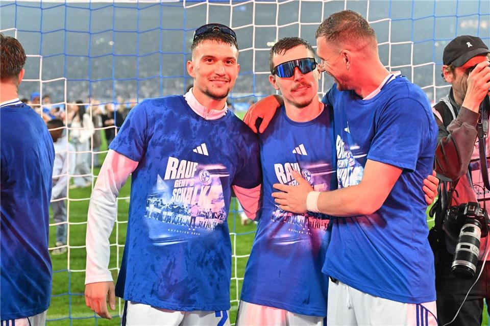 Felipe Sánchez (l, ), Ron Schallenberg (M) und Stürmer-Star Edin Dzeko jubeln über den Aufstieg.Bernd Thissen/dpa