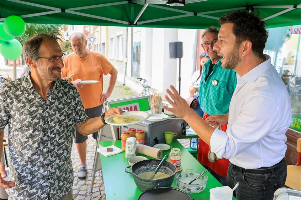 Felix Banaszak (r, Bündnis 90/ Die Grünen), Bundesvorsitzender, verteilt im Rahmen des Wahlkampfes vor der Landtagswahl in Sachsen-Anhalt Crêpes an Passanten.Jan Woitas/dpa