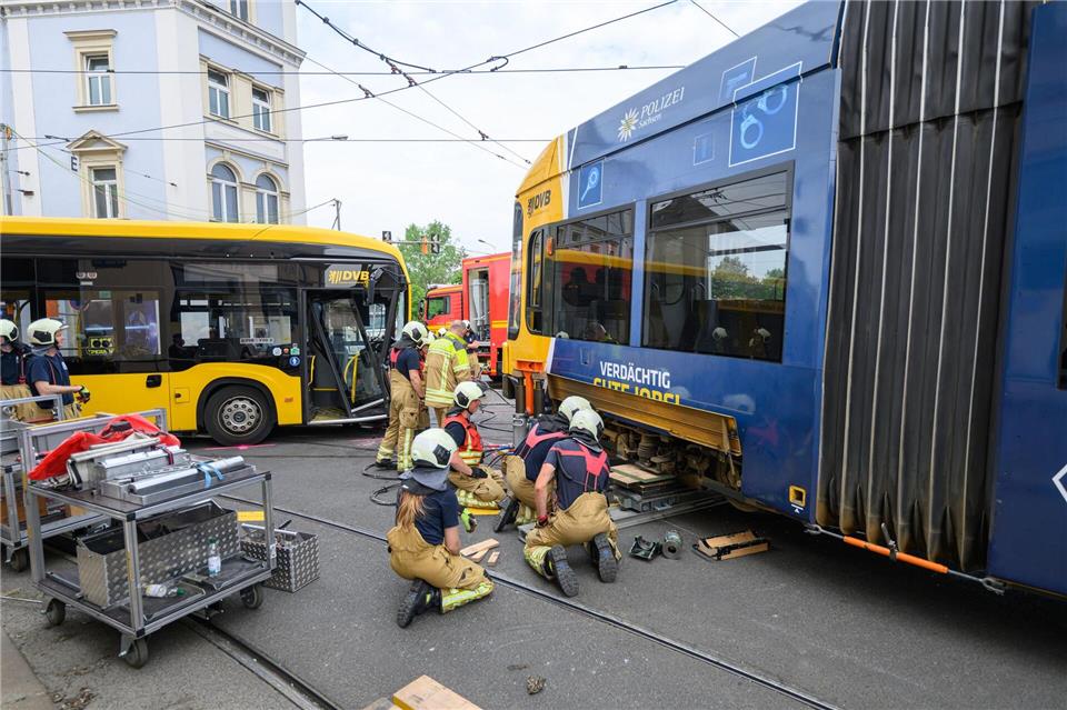 Feuerwehr hebt entgleiste Straßenbahn nach Unfall wieder ins Gleis.Robert Michael/dpa