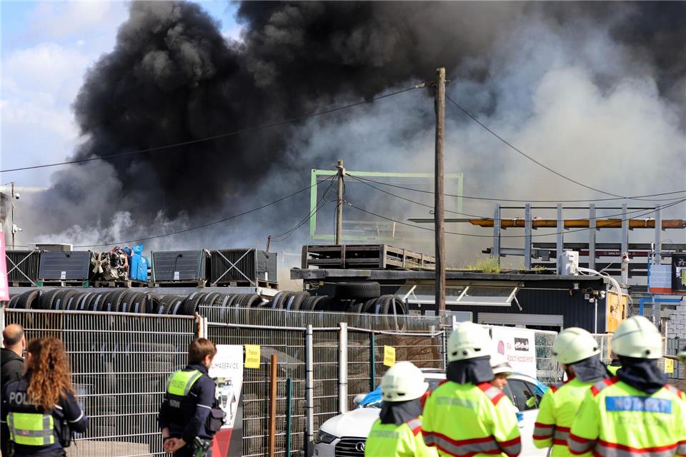 Feuerwehr und Polizei sind im Einsatz bei einem Brand in einer Werkstatt in einem alten Industrieareal - die dichte Rauchwolke ist weithin sichtbar.Sascha Thelen/dpa