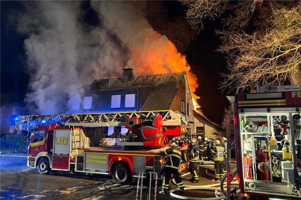 Feuerwehrleute löschen das brennende Haus.Justin Brosch/dpa