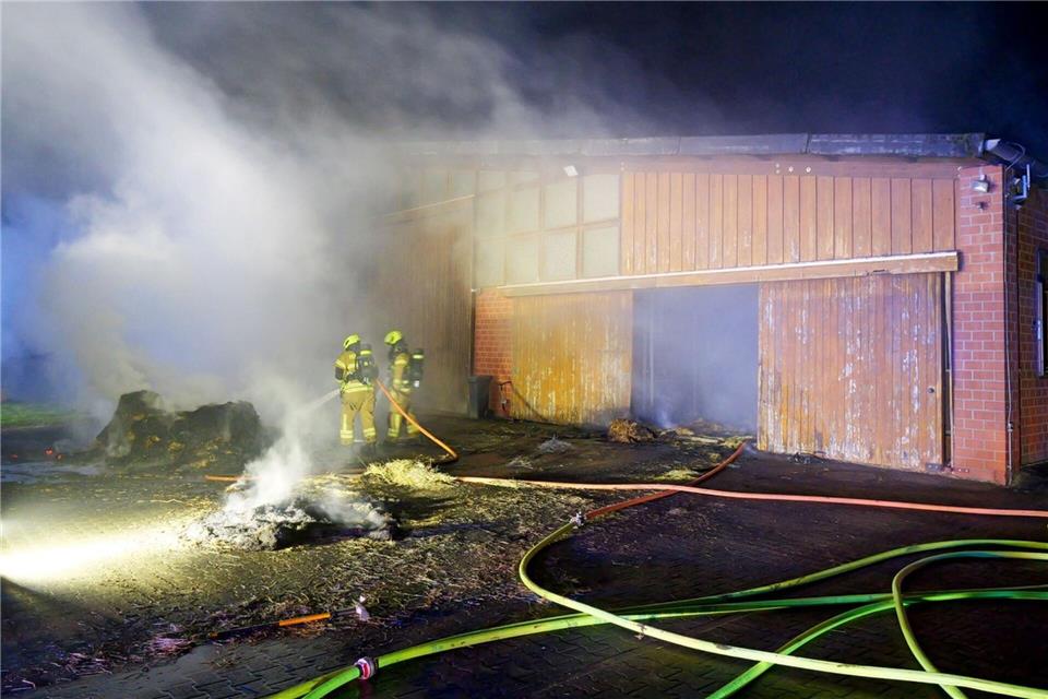 Feuerwehrleute löschen den Brand in dem Pferdestall. Feuerwehr Paderborn/dpa