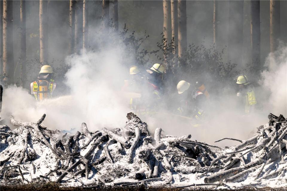 Feuerwehrleute löschen einen Böschungsbrand zwischen Sauerlach und Hofolding in der Nähe der Autobahn A8.Peter Kneffel/dpa