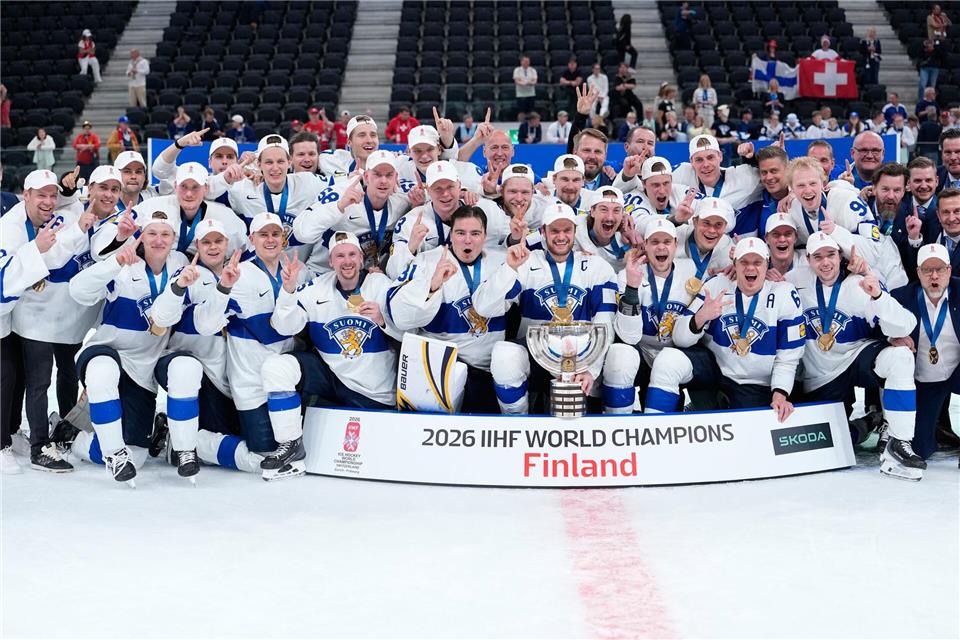 Finnische Spieler feiern mit der Trophäe nach dem Sieg im Endspiel.Darko Bandic/AP/dpa
