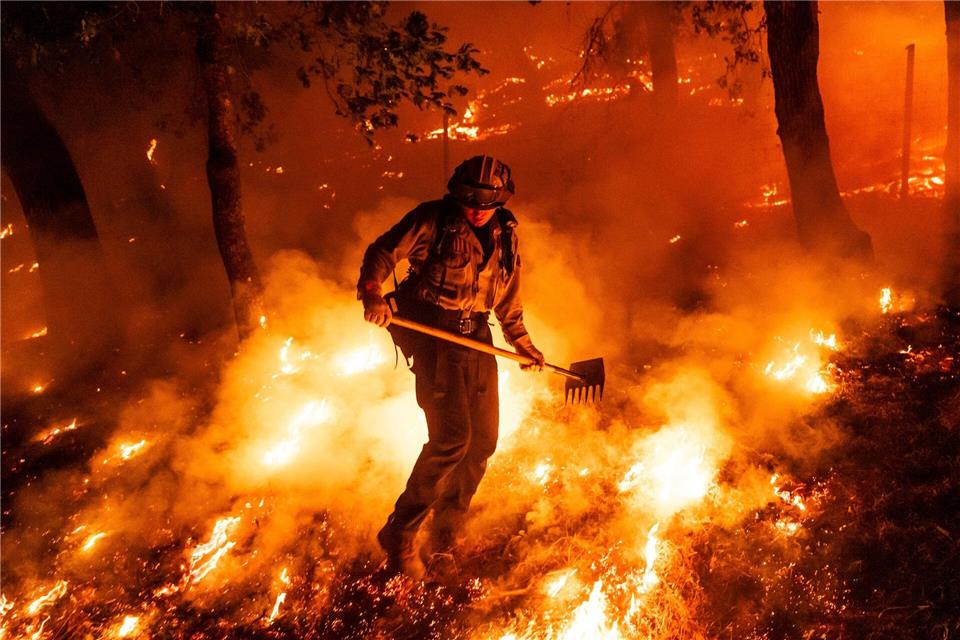 Flammen des Pickett-Feuers umzingeln einen Feuerwehrmann in Kalifornien.Noah Berger/AP/dpa