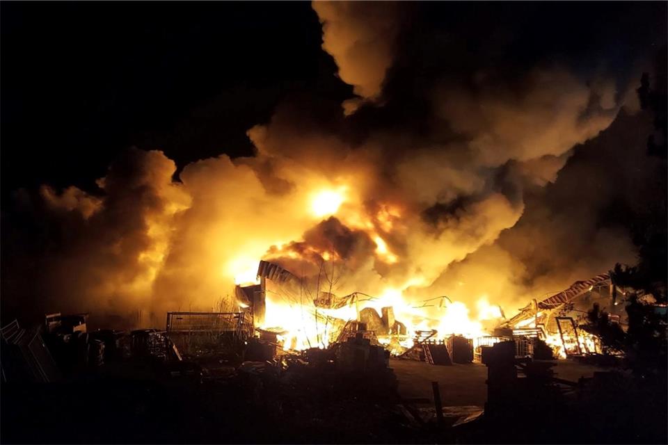 Flammen schlagen aus einer großen Lagerhalle in Ibbenbüren, die in der Nacht zum Sonntag ausgebrannt ist. Bei dem Feuer habe es keine Verletzten gegeben, teilte ein Sprecher der Leitstelle in Steinfurt in der Nacht mit. In der Halle gelagerte Propanflaschen seien explodiert.