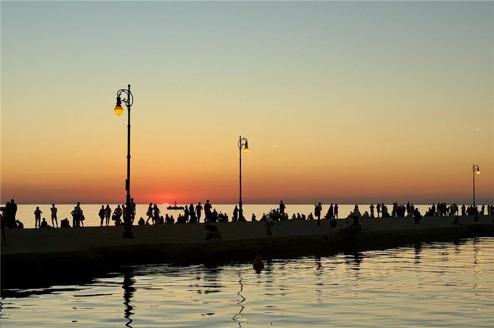 Flanieren, wenn die Sonne tief steht, ist Volkssport an der Molo Audace.Wolfgang Stelljes/dpa-tmn