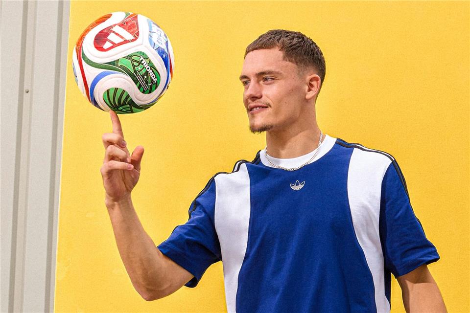 Florian Wirtz mit dem offiziellen WM-Spielball „Trionda“.---/Adidas/dpa