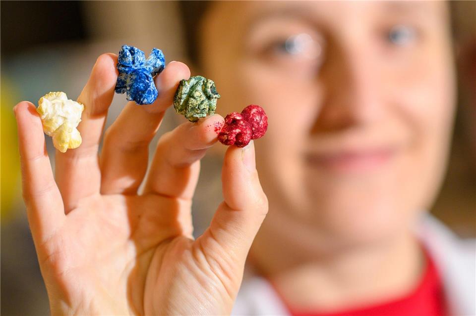 Franziska Kehling, Studentin an der Hochschule Anhalt, zeigt farbiges Popcorn, das in der Lehrküche der Hochschule mit Mikroalgen bunt eingefärbt wurde.Klaus-Dietmar Gabbert/dpa
