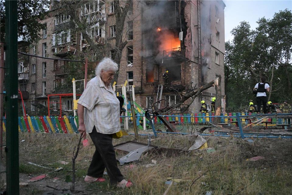 Frau passiert brennendes Wohnhaus nach russischem Angriff in KiewDanylo Antoniuk/AP/dpa