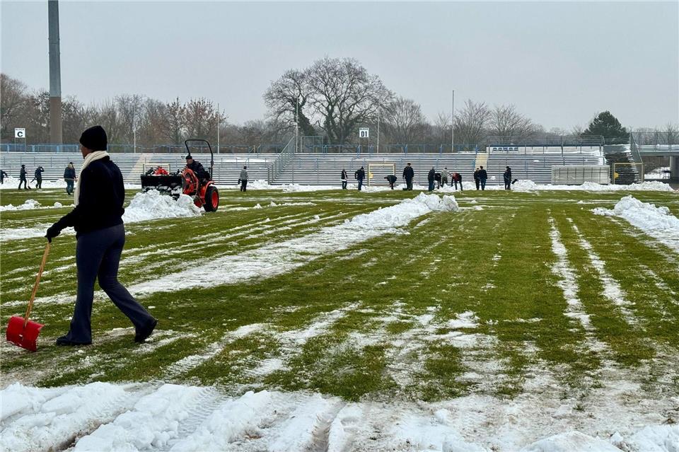 Freiwillige räumen Schnee von der Spielfläche im Dessauer Paul-Greifzu-StadionThomas Schulz/dpa