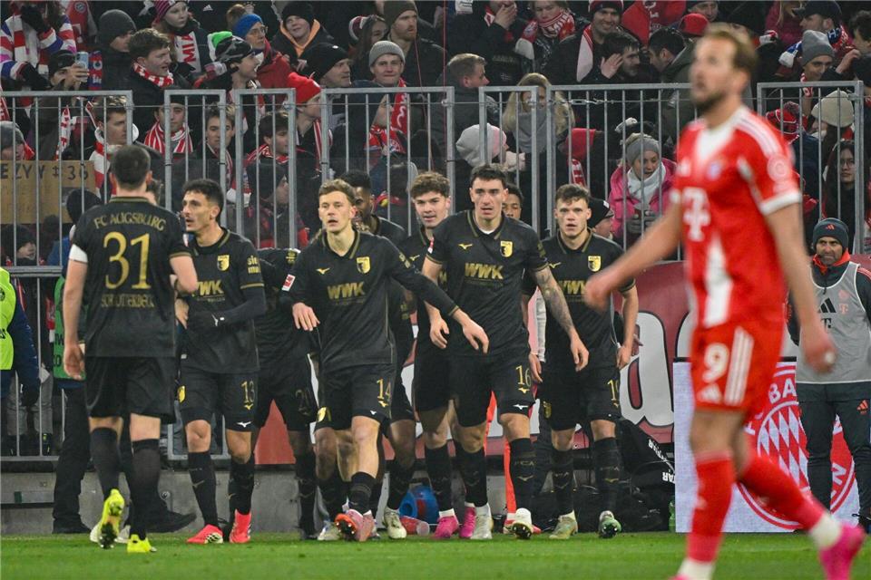Freude beim FC Augsburg, Enttäuschung bei Harry Kane.Peter Kneffel/dpa