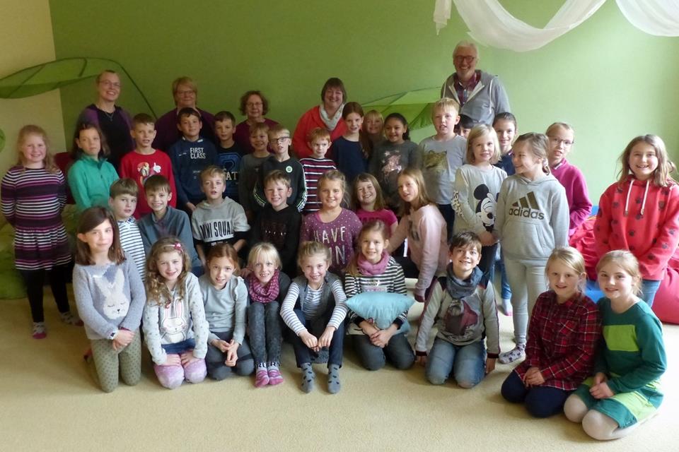 Freuen sich über die gelungene Lesung (hinten von links): Astrid Hudournik, Meike Bathe (Klassenlehrerin), Lydia Bart (pädagogische Mitarbeiterin), Jutta Weber (Leiterin der Bücherei) und Autor Joachim Friedrich mit den Silvesterschülern.